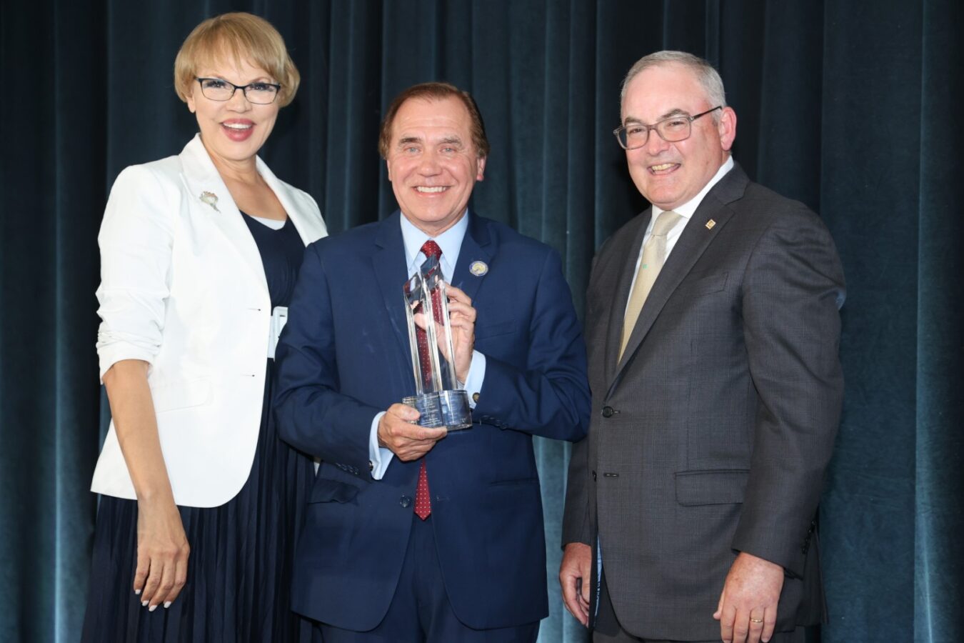 Picture of New Jersey Assembly Speaker Craig J. Coughlin (center) received the 2024 Humanitarian Award at Mercer Street Friends’ Fourth Annual Leadership Awards Celebration. Claire Babineaux-Fontenot, CEO, Feeding America (left) and Bernie Flynn, CEO, Mercer Street Friends (right) presented Coughlin with the Award. 